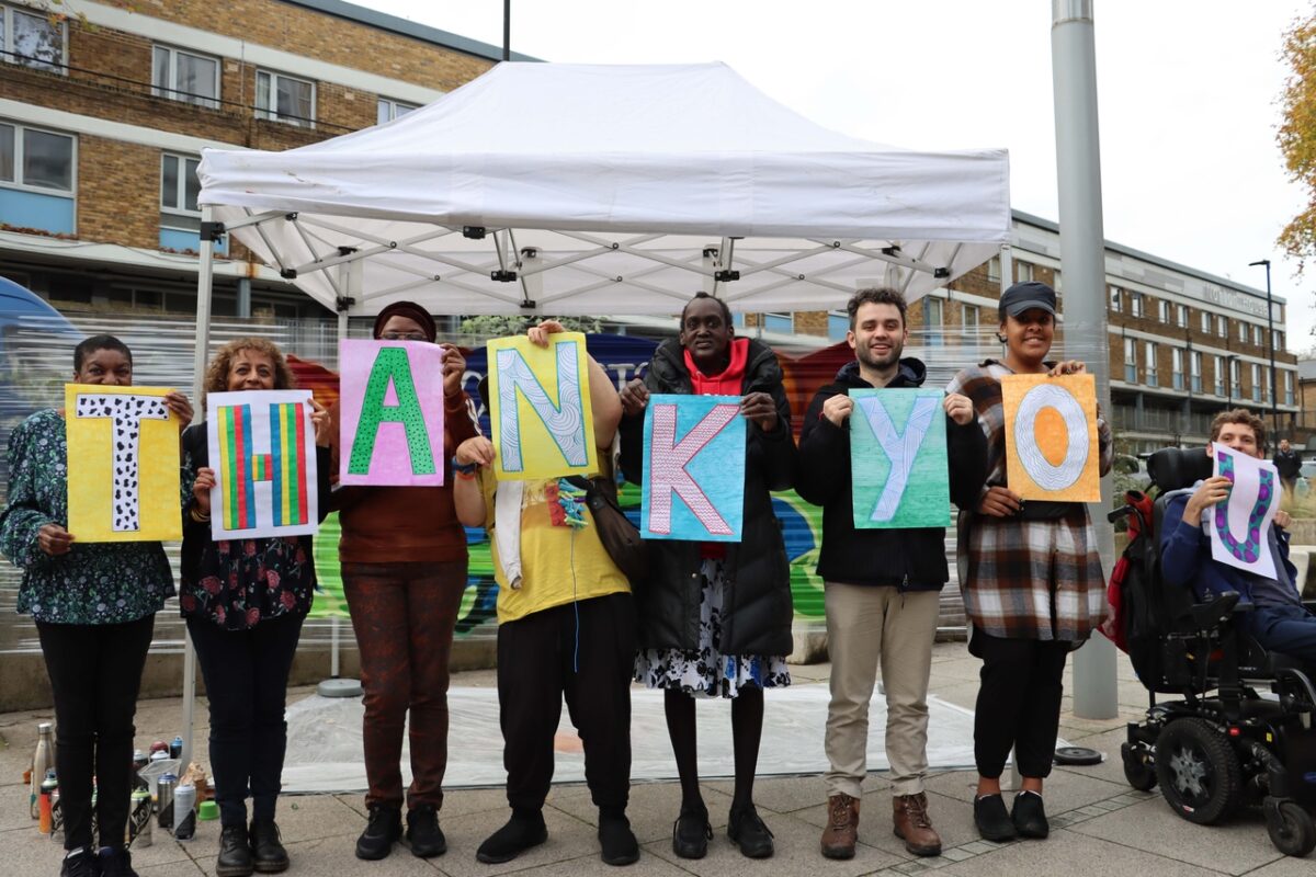 8 people hold signs that all together read' thank you'