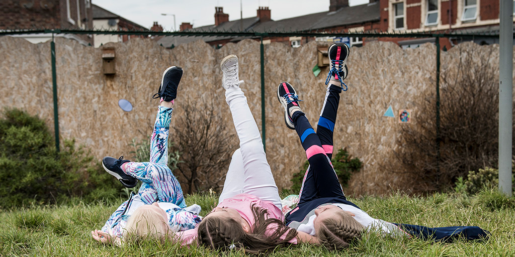 girls from Backyard Nature campaign lying on grass